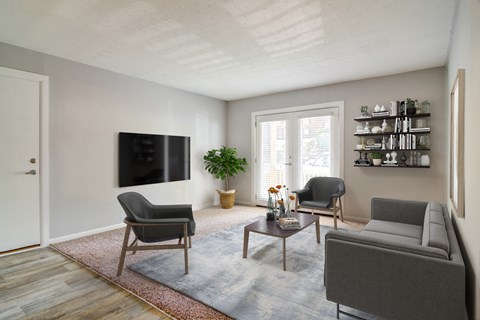 a living room with a couch and chairs and a television